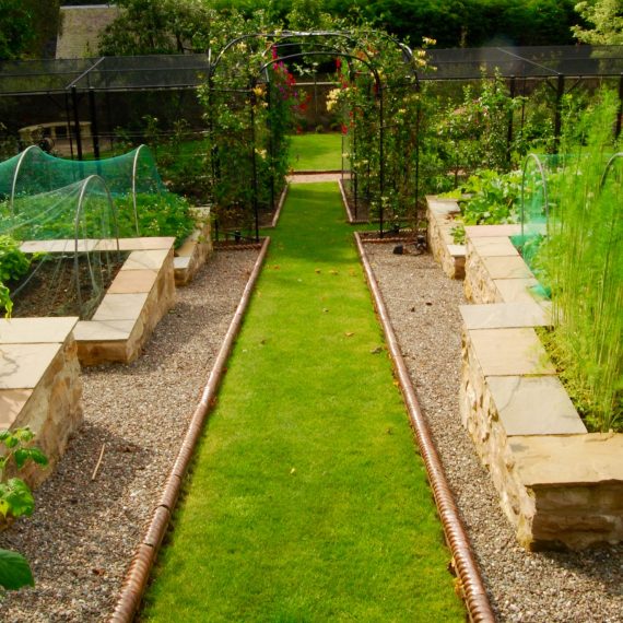 Lawn paths and raised vegetable beds, roses arbours, designed by Carolyn Grohmann