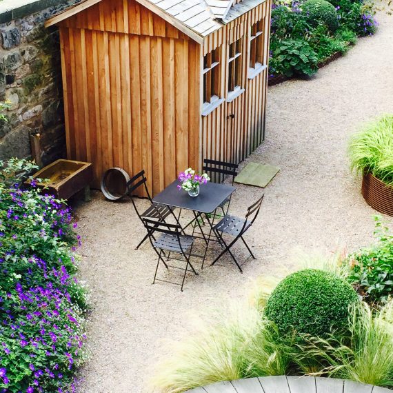 Scottish larch garden shed with Fermob bistro table and chairs