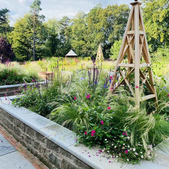 Stone raised beds with timber obelisks
