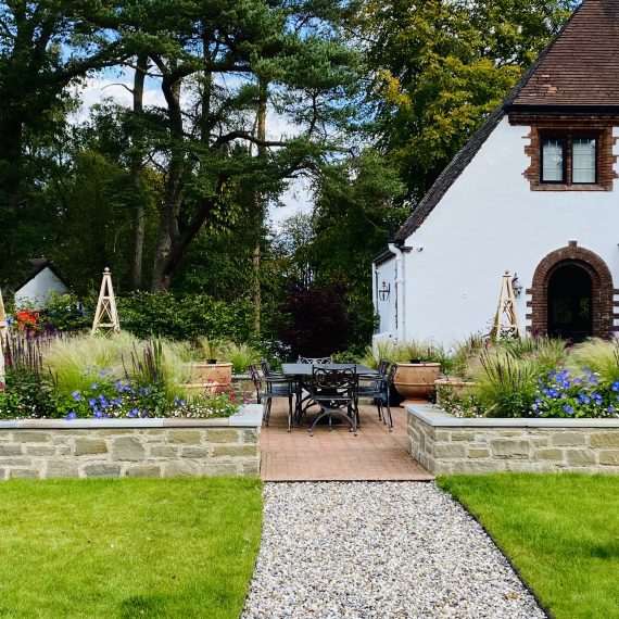 Stone raised beds with timber obelisks