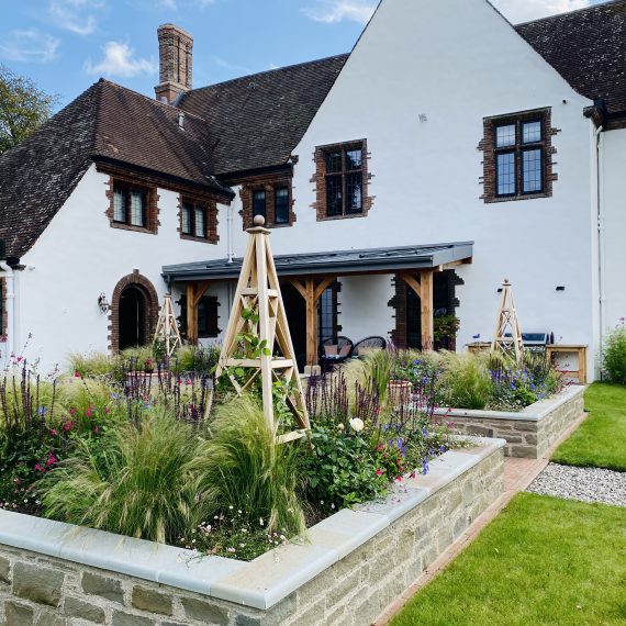 Stone raised beds with timber obelisks