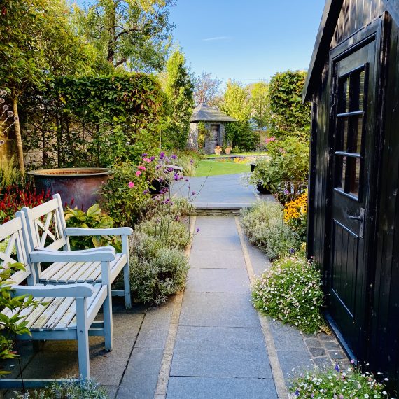 Posh Shed in side garden with seating and copper water feature