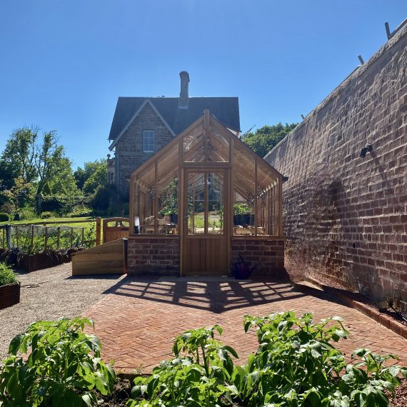 Woodpecker Joinery cedar greenhouse with paver workspace