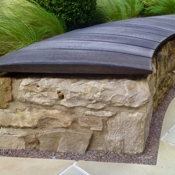 Stone bench with scorched oak seat