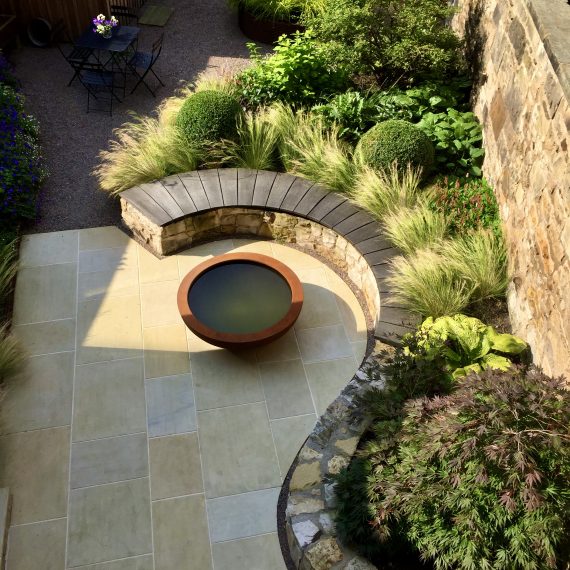 Curved stone wall, oak bench top and Urbis lily bowl