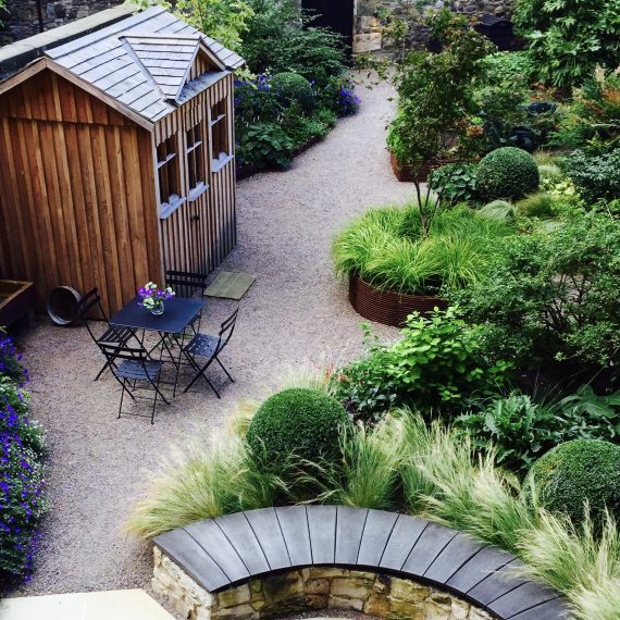 Scottish larch garden shed with stone bench and scorched oak seat