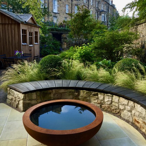 Curved stone wall, oak bench top and Urbis lily bowl