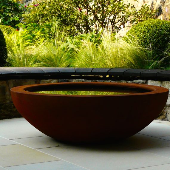 Curved stone wall, oak bench top and Urbis lily bowl