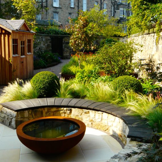 Curved stone wall, oak bench top and Urbis lily bowl