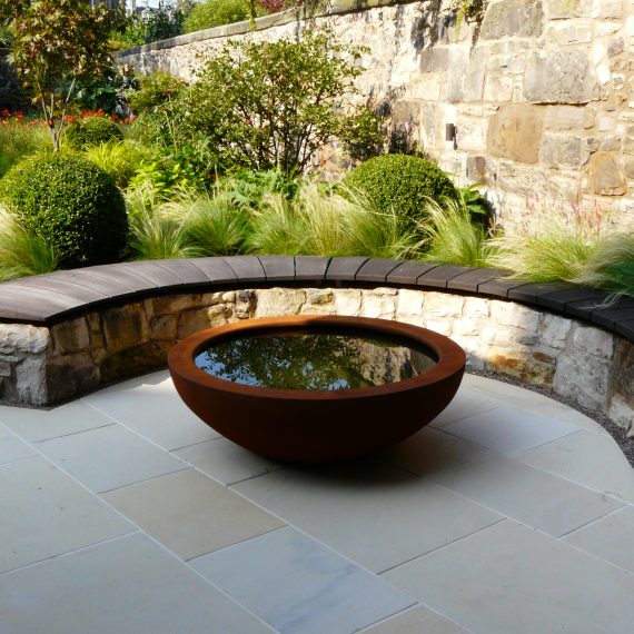 Curved stone wall, oak bench top and Urbis lily bowl