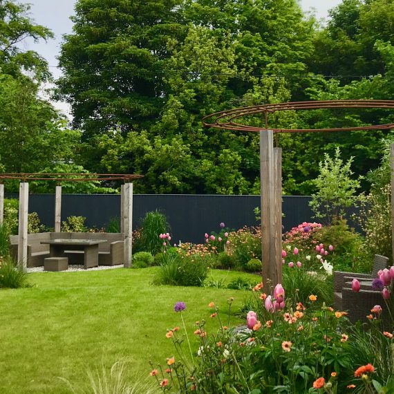Larch and rebar pergolas, circular lawns and lush herbaceous planting designed by Carolyn Grohmann
