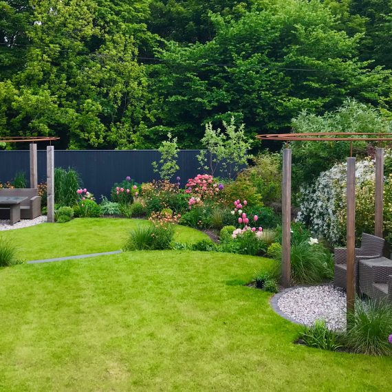 Larch and rebar pergolas, circular lawns and lush herbaceous planting