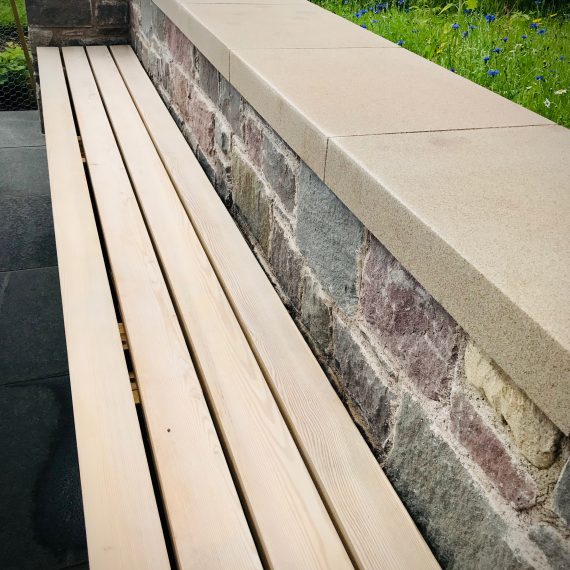 Walling to match house walls, Siberian larch bench to match house cladding. Designed by Carolyn Grohmann