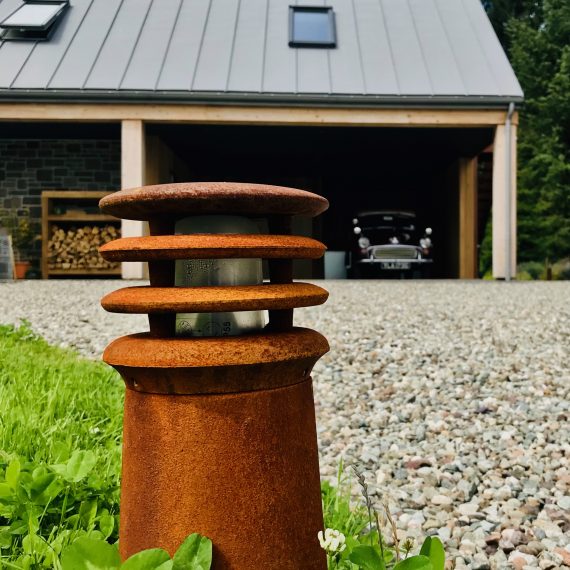 Rusty bollard light at edge of driveway with species rich turf. Designed by Carolyn Grohmann